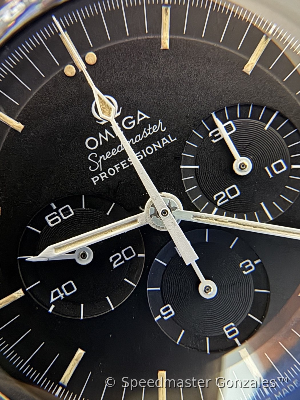 Macro of the collector's Speedmaster dial — the Omega script and applied logo