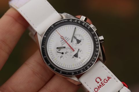 In hand — the 42 mm steel case on the white Omega strap