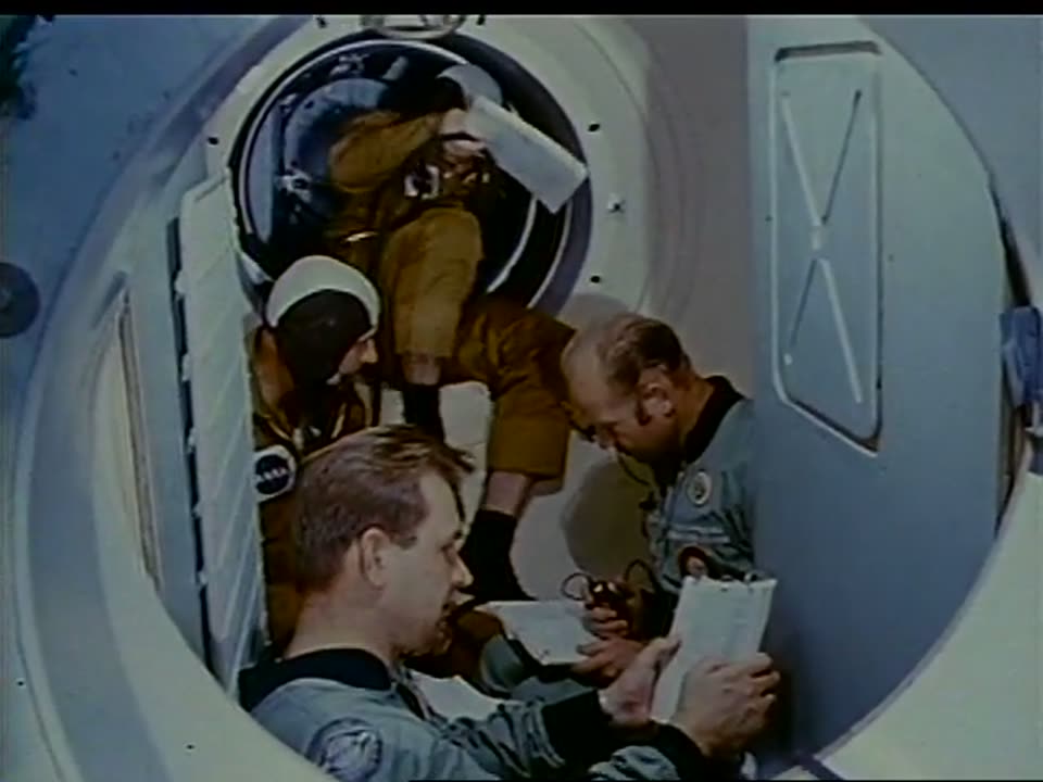 American and Soviet crewmen passing through the docking-module hatch trainer
