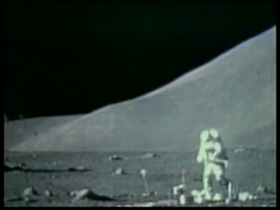 An Apollo 17 astronaut working on the lunar surface beneath the Taurus-Littrow mountains